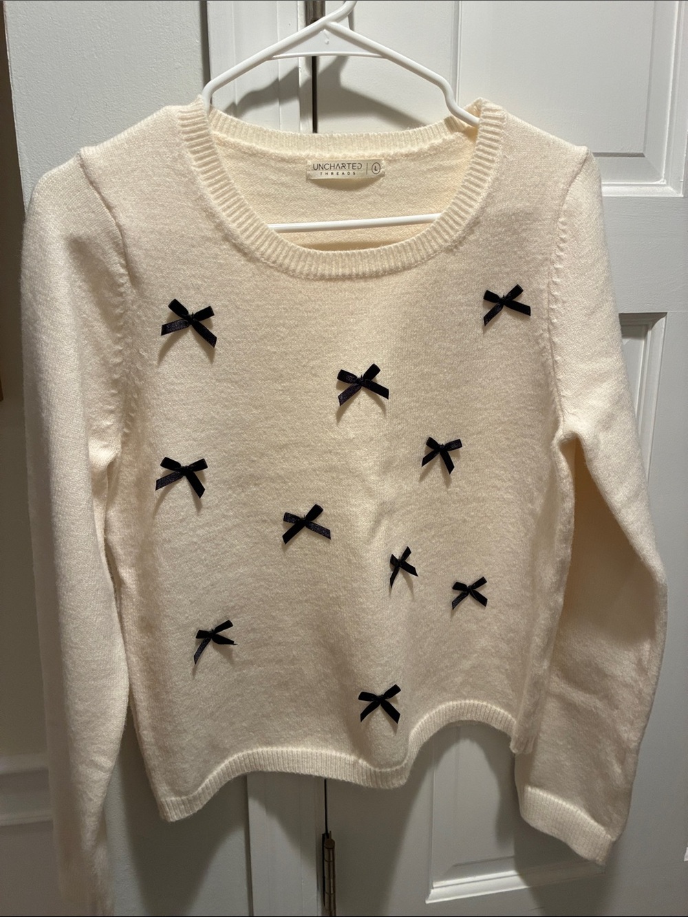 Uncharted Threads Cream Sweater with Black Bow Accents